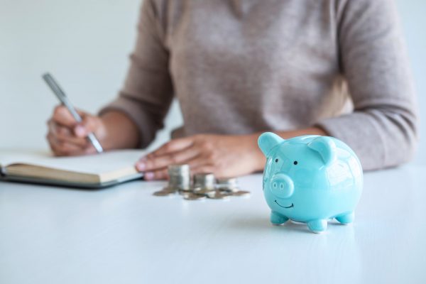 Young woman and piggy bank to planning growing saving strategy with pile coins for future plan fund